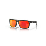 "Gafas de sol con un marco negro y lentes espejadas en tonos rojo y naranja. Las gafas tienen una forma rectangular con un diseño ligeramente curvado. Hay dos pequeños remaches metálicos en cada lado del marco cerca de las lentes y un pequeño logotipo en el brazo derecho."