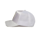 "Muestra una gorra de color blanco vista de lado. La gorra tiene una visera curva y una malla en la parte trasera, característica típica de las gorras de camionero para proporcionar ventilación. El panel frontal parece tener un parche o diseño, aunque los detalles del diseño no son visibles desde este ángulo. Esta imagen es relevante para aquellos interesados en accesorios de moda, especialmente gorras, ya que muestra el estilo y la estructura de una gorra de camionero."