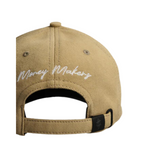 "Gorra Money Makers en base textil color kaki con bordado blanco en el frente de alto relieve, bordado lateral y posterior con hebilla metálica ajustable."